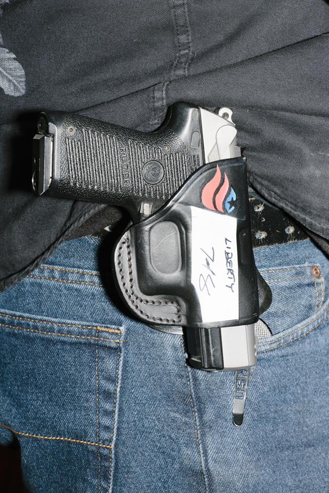 A pistol in a holster with Ted Cruz's campaign logo and his autograph hangs on the belt of Marc McInnis, of Salem, New Hamsphire, as Texas senator and Republican presidential candidate Ted Cruz speaks at a Second Amendment Rally outside Granite State Indoor Range in Hudson, New Hampshire. Above the autograph, Cruz also wrote "liberty."