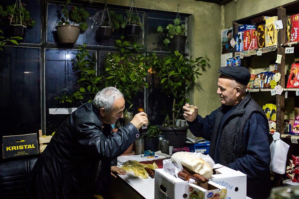 Two old friends from period before the war, Seljami and Stajko, are toasting in a small store belonging to the later one, in the village of Velika Hoca inhabited by Serbs. Seljami, who is Kosovo Albanian, comes here often from nearby Orhovac to meet his Serbian friend, without fear that anything could happen to him. He stays for hours, talking with Stajko in clear Serbian language, about the past times when ethnicity and religion didn't mean that much as they do today in this region.